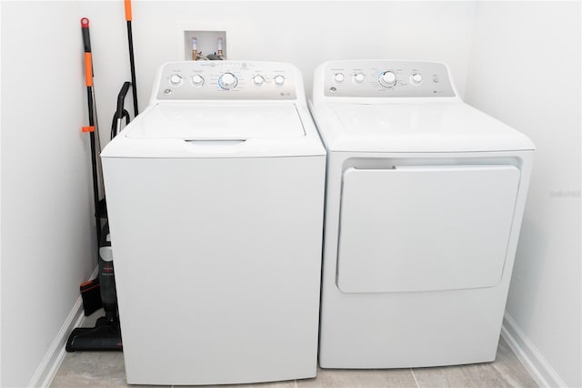 laundry area with laundry area, baseboards, and washing machine and clothes dryer