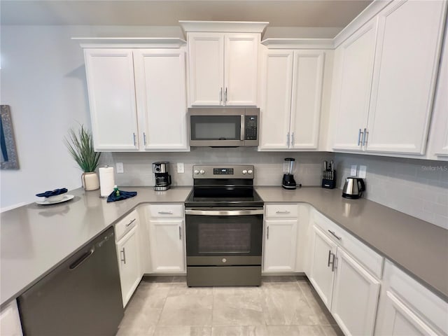 kitchen with tasteful backsplash, white cabinetry, light tile patterned flooring, and appliances with stainless steel finishes