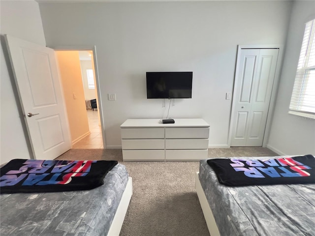 carpeted bedroom featuring multiple windows and a closet