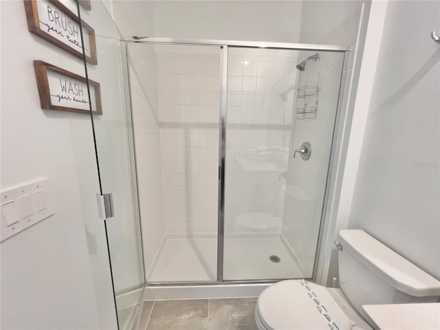 full bathroom featuring a shower stall, toilet, and tile patterned floors