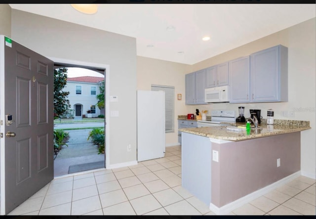 kitchen with kitchen peninsula, white appliances, light tile flooring, and light stone countertops