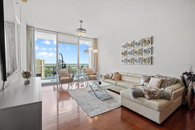 living room with floor to ceiling windows, a textured ceiling, and dark wood-type flooring