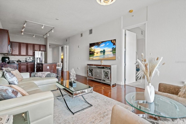 living room with track lighting, a textured ceiling, and hardwood / wood-style flooring