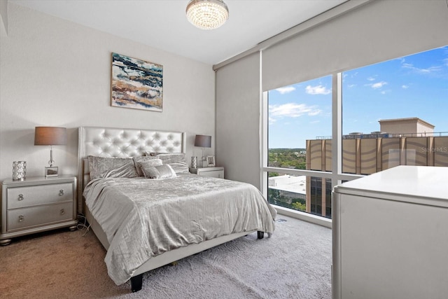 bedroom with a chandelier and dark carpet