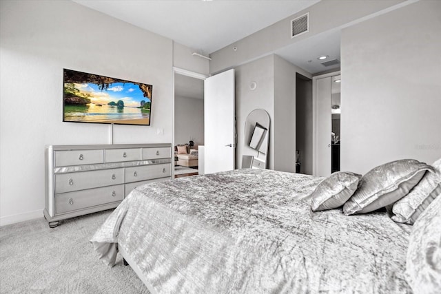 bedroom with light colored carpet and ensuite bathroom