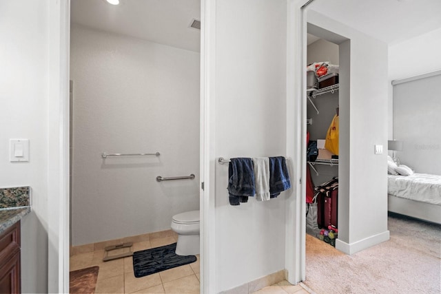 bathroom featuring toilet, vanity, and tile flooring