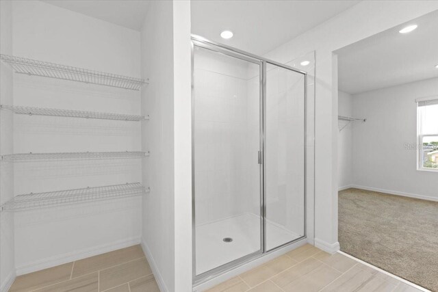 bathroom with a shower with door