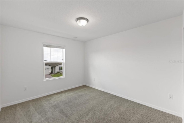 empty room featuring a textured ceiling and carpet