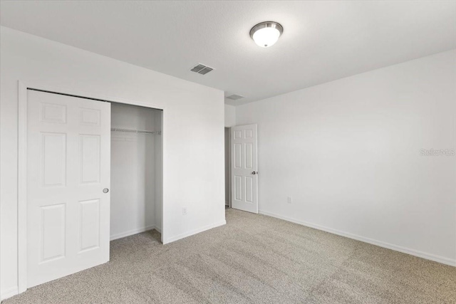 unfurnished bedroom featuring carpet flooring and a closet