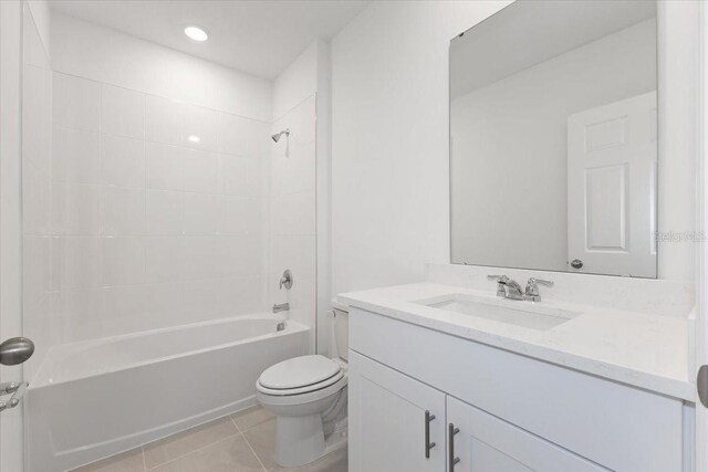 full bathroom featuring tiled shower / bath combo, vanity, tile patterned floors, and toilet