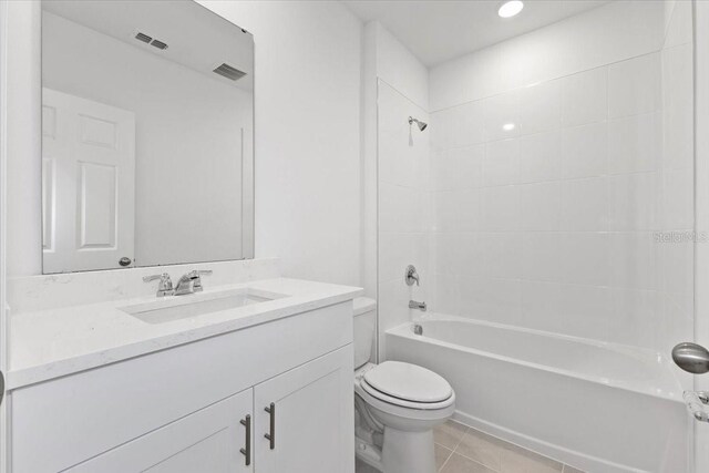 full bathroom featuring tile patterned flooring, vanity, toilet, and tiled shower / bath