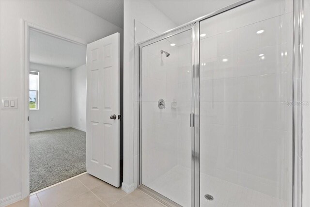 bathroom featuring a shower with door and tile patterned flooring