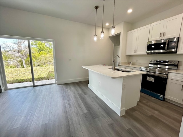 kitchen with pendant lighting, appliances with stainless steel finishes, sink, white cabinets, and an island with sink