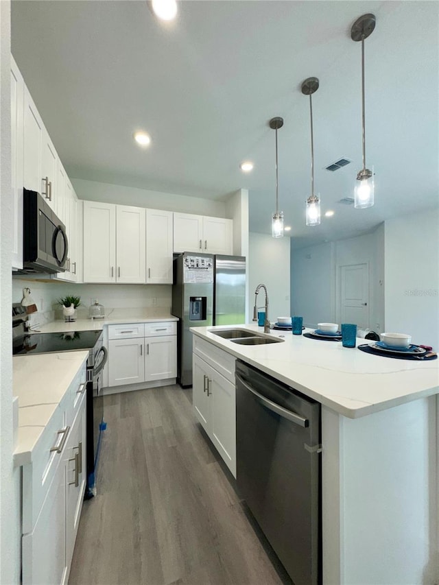 kitchen featuring sink, white cabinetry, pendant lighting, and stainless steel appliances