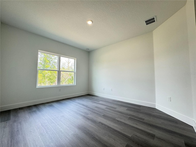 unfurnished room with a textured ceiling and dark hardwood / wood-style flooring