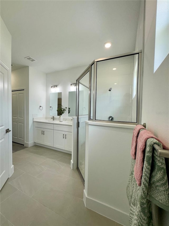 bathroom featuring vanity, tile patterned floors, and a shower with door