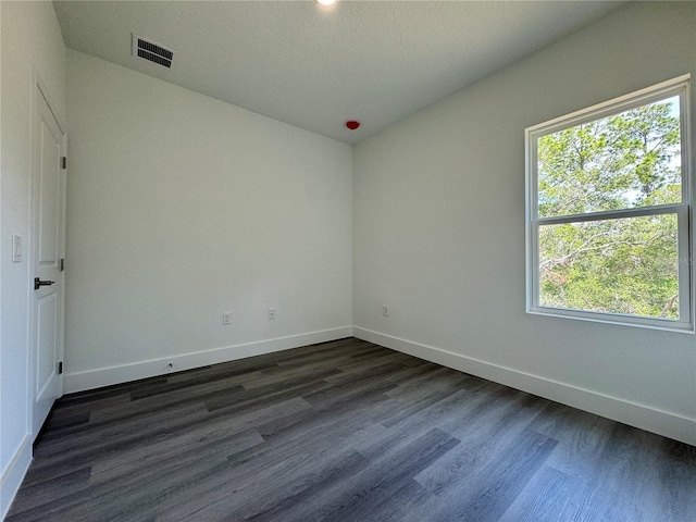 empty room with dark hardwood / wood-style flooring