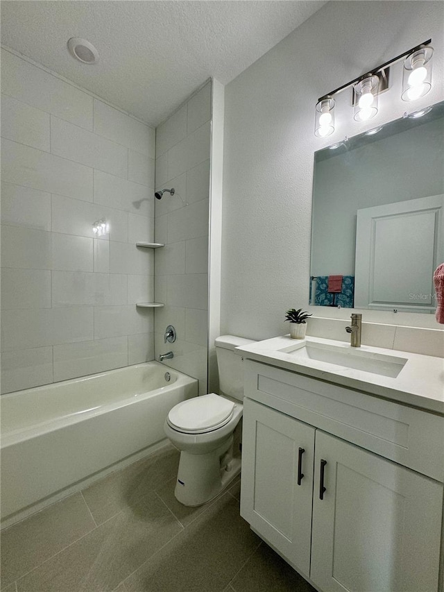 full bathroom with a textured ceiling, tiled shower / bath combo, tile patterned flooring, vanity, and toilet