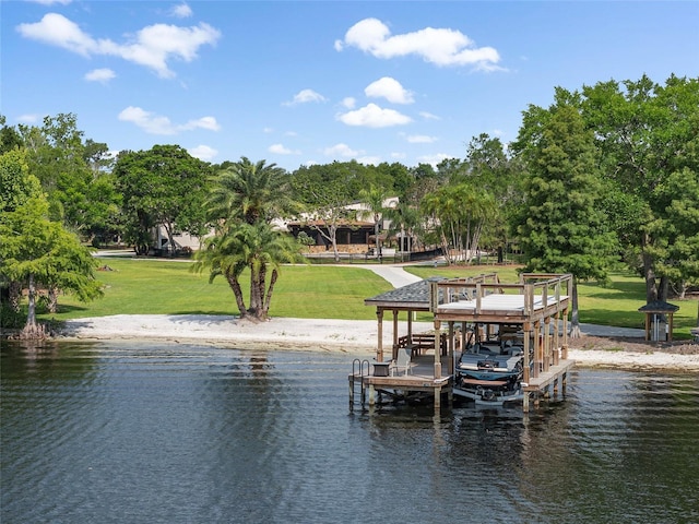 view of dock with a lawn and a water view