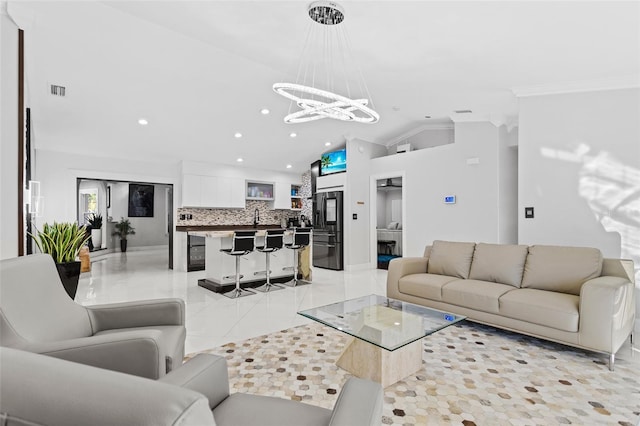 tiled living room with crown molding, lofted ceiling, and a chandelier