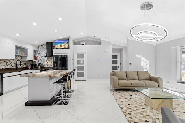 living room featuring ornamental molding, lofted ceiling, and sink