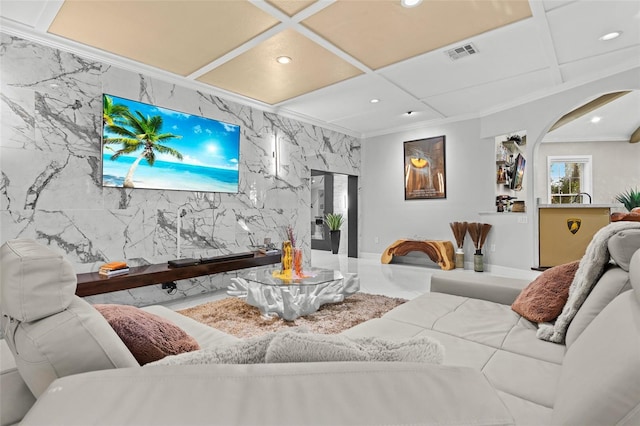 living room featuring coffered ceiling and tile walls