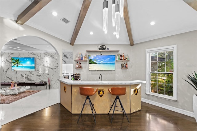 kitchen with sink, dark wood-type flooring, a breakfast bar area, vaulted ceiling with beams, and kitchen peninsula