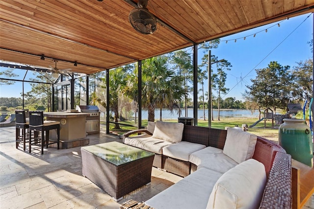 view of patio / terrace with outdoor lounge area, a grill, area for grilling, an outdoor bar, and a water view