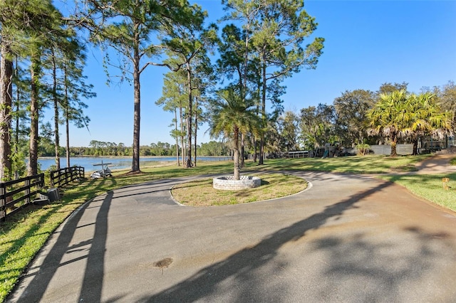 view of home's community with a water view and a lawn