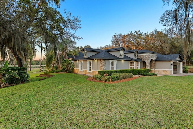 ranch-style house featuring a garage and a lawn