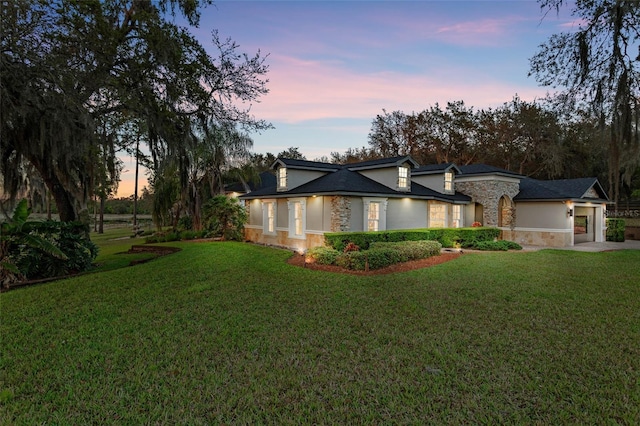 view of front of house featuring a garage and a lawn