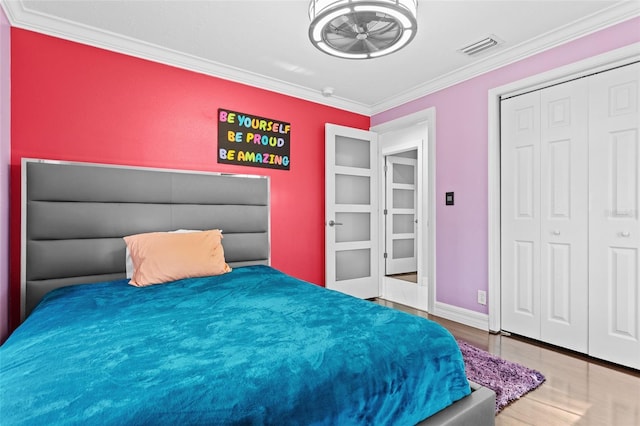 bedroom with ornamental molding, hardwood / wood-style floors, and a closet