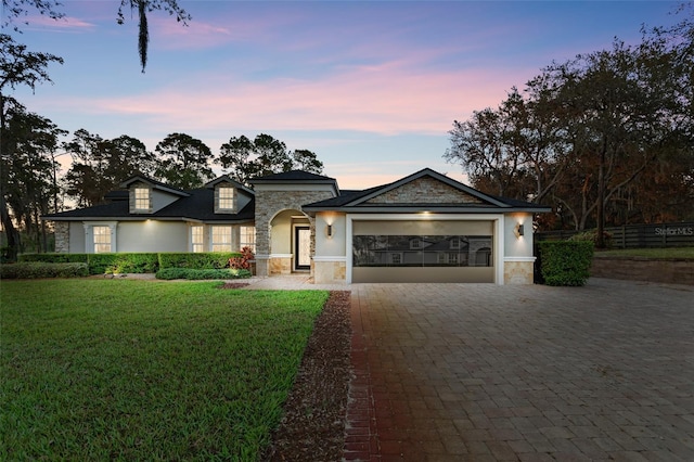 view of front of home with a garage and a yard