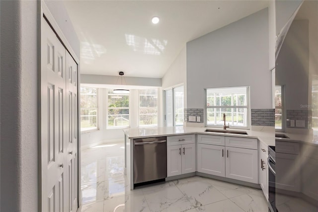 kitchen featuring lofted ceiling, sink, white cabinets, stainless steel dishwasher, and kitchen peninsula