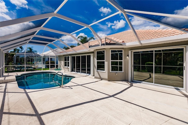 view of swimming pool featuring a patio and glass enclosure