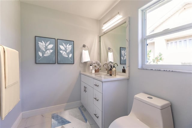 bathroom with plenty of natural light, toilet, and vanity