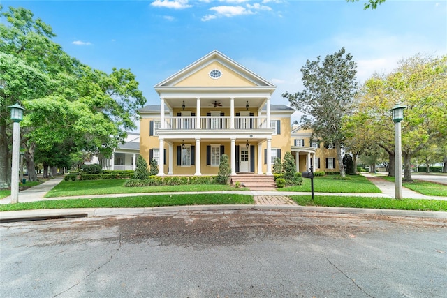 neoclassical home featuring a porch and a front yard