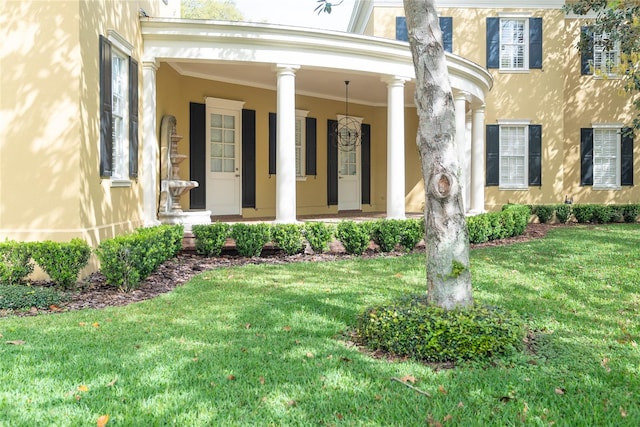 property entrance featuring covered porch and a lawn