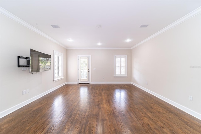 spare room featuring dark hardwood / wood-style floors, ornamental molding, and a healthy amount of sunlight