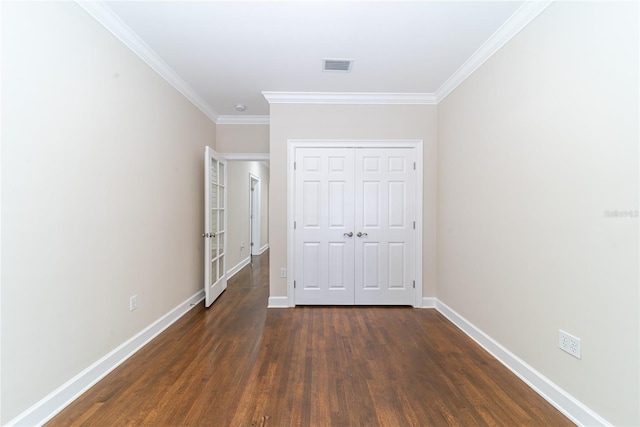 unfurnished bedroom featuring ornamental molding, a closet, and dark hardwood / wood-style floors