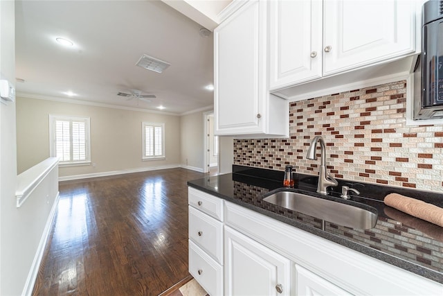 kitchen with ceiling fan, sink, wood-type flooring, tasteful backsplash, and white cabinetry