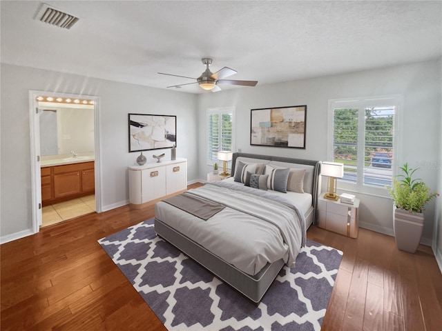 bedroom with ensuite bath, ceiling fan, light wood-type flooring, and sink