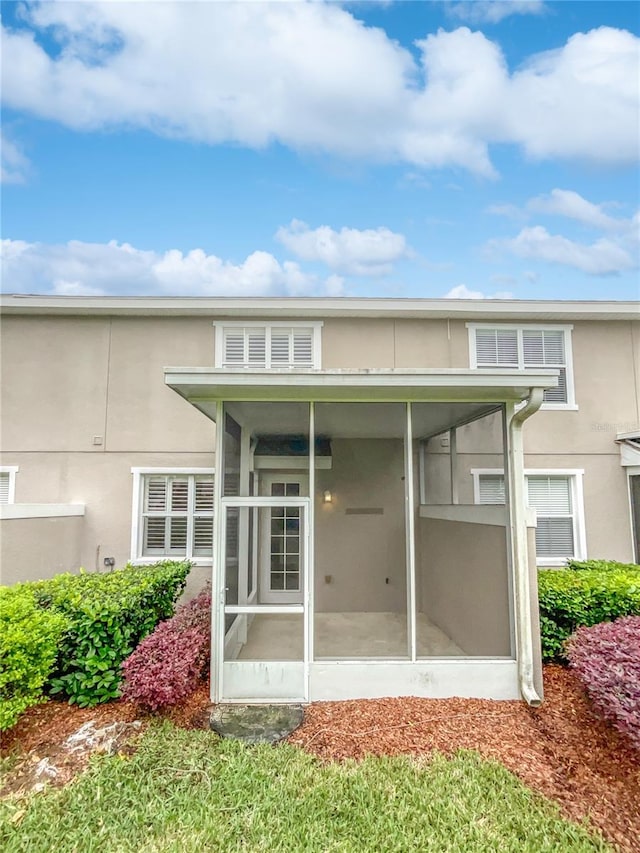 back of property with a sunroom