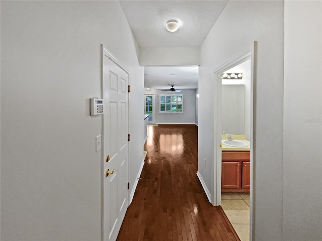 hall with sink and light tile floors