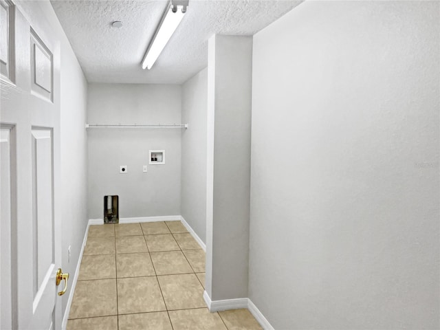 laundry room featuring hookup for a washing machine, hookup for an electric dryer, light tile floors, and a textured ceiling