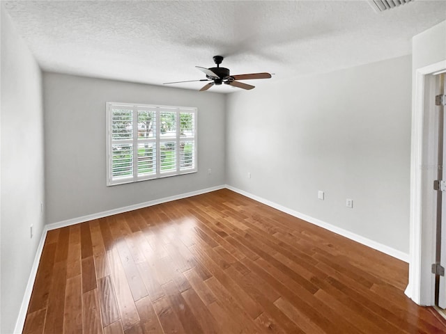 empty room with dark wood-type flooring, a textured ceiling, and ceiling fan