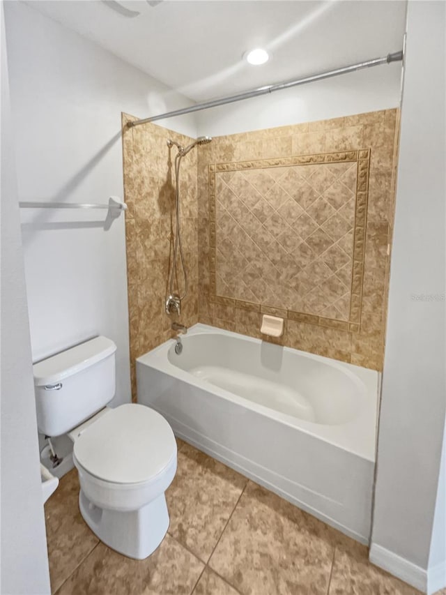 bathroom featuring toilet, tiled shower / bath, and tile flooring