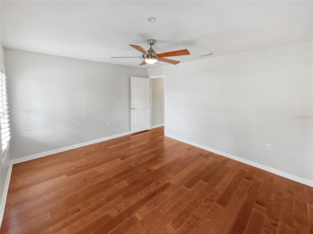 spare room featuring ceiling fan and dark hardwood / wood-style flooring