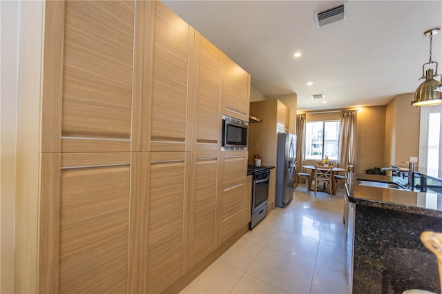 kitchen with decorative light fixtures, light brown cabinetry, stainless steel appliances, light tile floors, and sink