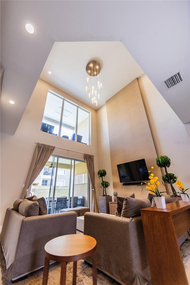 living room with a towering ceiling and a chandelier